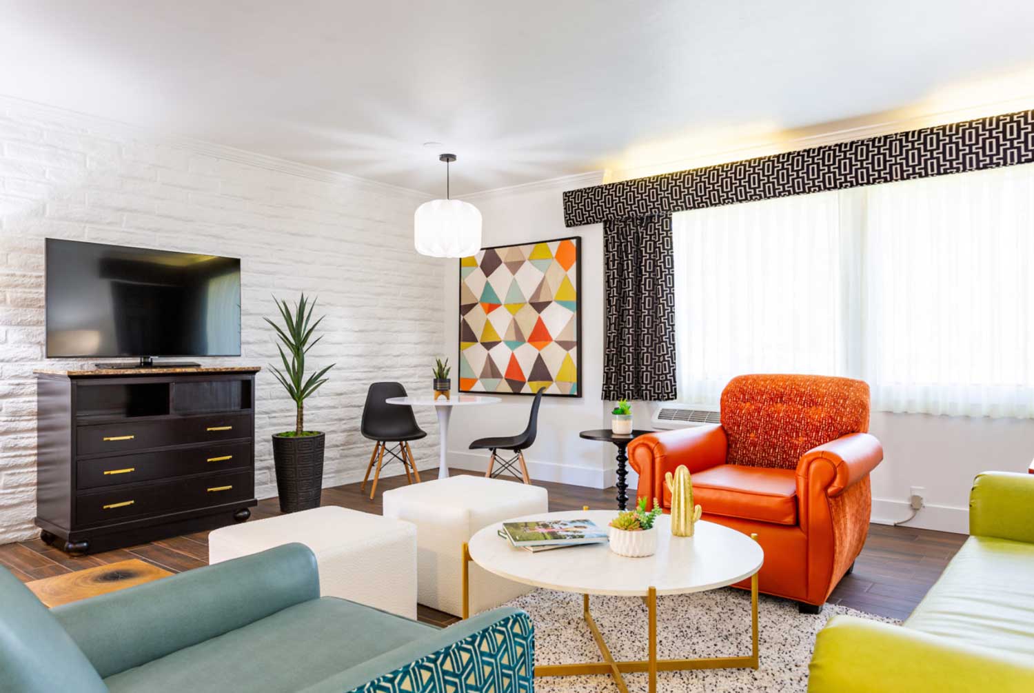 Retro hotel living room with teal, ivory, and orange furniture